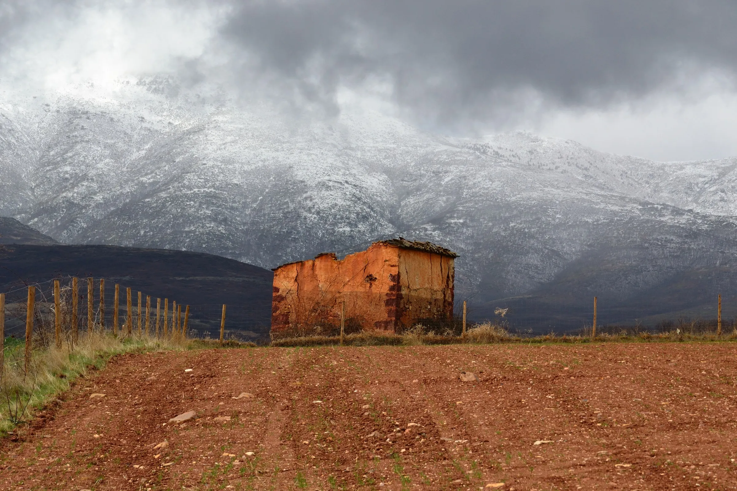 La sierra nevada sobre los campos de Villacorta, con un palomar de adobe en primer plano