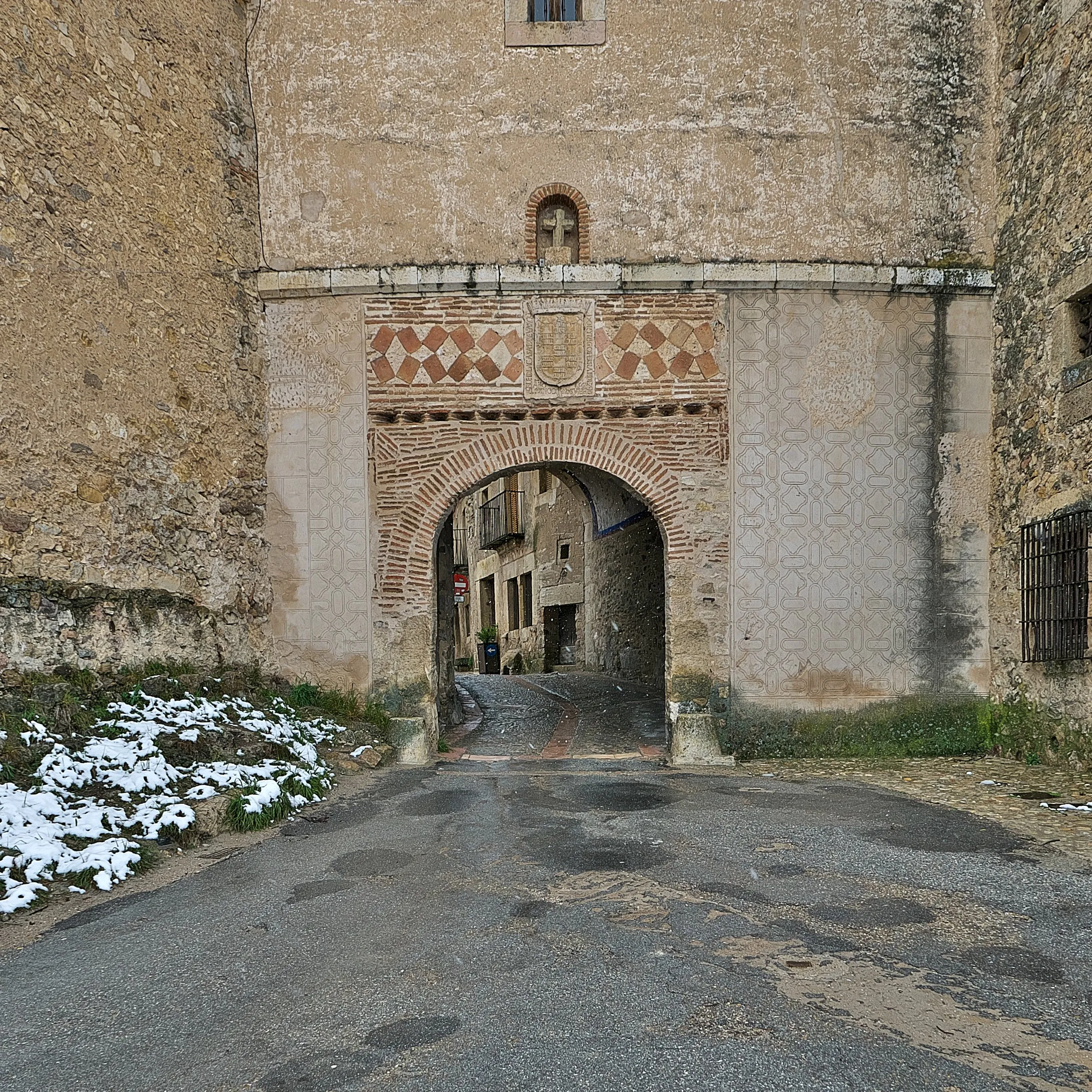 La puerta de la villa de Pedraza, con el arco de sillería y el escudo sobre él